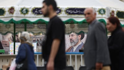 People walk past a banner with a picture of Supreme Leader Mojtaba Khamenei in Tehran. Reuters