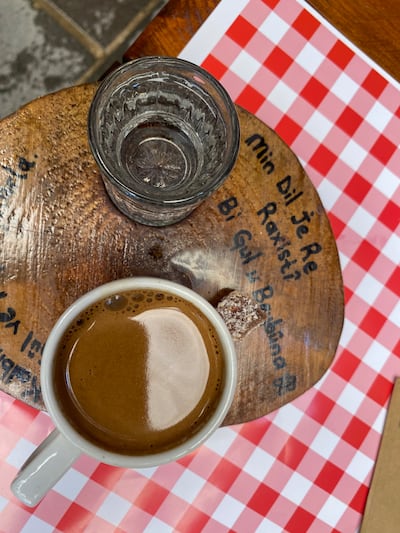 Coffee served on a wooden saucer with Kurdish language detail. Photo: Lizzie Porter / The National