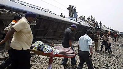 Rescue workers carry an injured passenger away from the overturned carriages of a train in the Jhargram area of West Bengal yesterday.