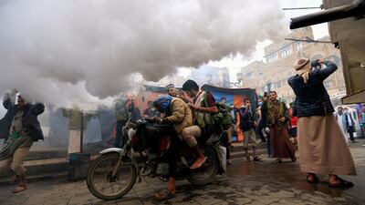 A Yemeni man drives his motorcycle through a cloud of disinfectant substance used against the novel coronavirus, as workers fumigate a street in the old city market of the capital Sanaa. AFP