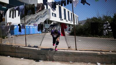 A migrant boy breaks through the fence at a temporary camp for migrants on June 5, 2016. Angelos Tzortzinis / Agence France-Presse