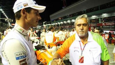Dr Vijay Mallya, right, congratulating one of his drivers, Adrian Sutil, after the Singapore GP, is refuting reports that he is interested in selling the Force India team.