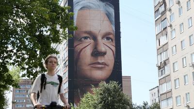 A person rides past a mural depicting WikiLeaks founder Julian Assange in the town of Balashikha outside Moscow on Tuesday. EPA