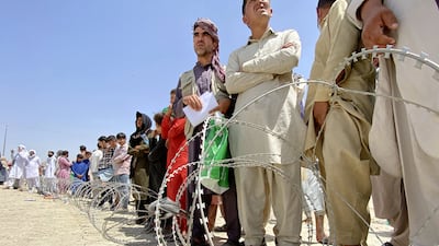 Afghans including those who worked for the US, Nato, EU and the UN in Afghanistan wait outside the Hamid Karzai International Airport to flee the country after Taliban took control of Kabul in August 2021. EPA