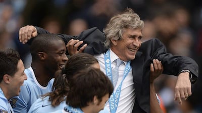 Manchester City manager Manuel Pellegrini is thrown into the air by his team as they celebrate winning the Premier League title on Sunday. Nigle Roddis / Reuters / May 11, 2014