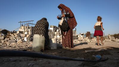 A displaced Palestinian woman waits to refill water bottles at a makeshift camp in Khan Younis, southern Gaza Strip. EPA