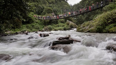 Devotees cross a suspended bridge. Narendra Shrestha/EPA