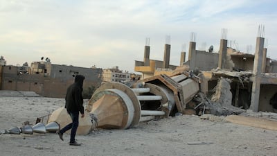 A Syrian man walks past a minaret destroyed following an alleged air strikes by Syrian government forces in the ISIS controlled Syrian city of Raqqa, on November 25, 2014. AFP