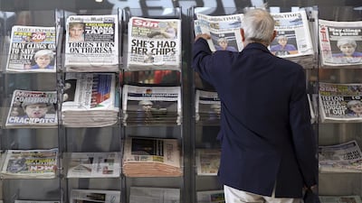 A man picks up a newspaper reporting the development following Britain's general election at a shop in Westminster in London. Tim Ireland / AP Photo