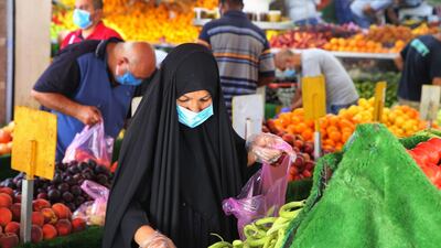 An Iraqi woman shops at a street market in the Karrada neighbourhood of Baghdad. Job losses and soaring prices have left more and more Iraqis unable to afford basic goods. AFP