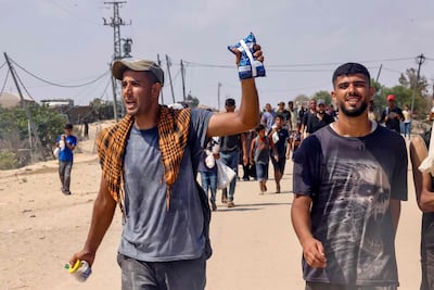 A Palestinian man shows a small bag of humanitarian aid received, in Al Mawasi, in southern Gaza. AFP