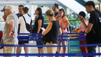Stranded passengers wait at the Qatar Airways customer service at I Gusti Ngurah Rai International Airport on March 1, 2026, after flights to Doha, Dubai, and Abu Dhabi were cancelled following strikes on Iran launched by the US and Israel. Reuters