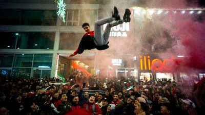A young man is thrown in the air by Moroccan supporters as part of celebrations in Milan, Italy. AP