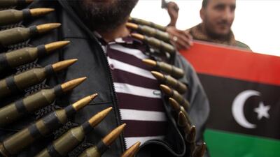 A Libyan protester shows ammunition confiscated from soldiers as another holds his country's old flag in Benghazi on February 25, 2011, during the uprising against Muammar Qaddafi and his forces. Patrick Baz / AFP Photo