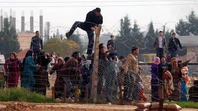 Syrians try to cross the border from their town of Ras Al Ain to the Turkish border town of Ceylanpinar after an air strike.