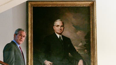 Mr Bush walks past a portrait of former President Harry S Truman as he descends the Grand Staircase of the White House in Washington. AP
