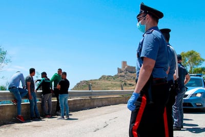 Italian police detain and check migrants found on a roadside in Palma di Montechiaro, in Sicily. AFP