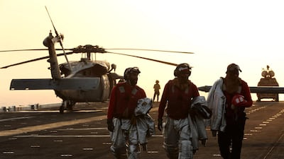 Firefighters walk away after the landing of an MH-60S Sea Hawk.
