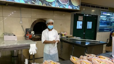 An employee of a bakery waits for customers in the nearly deserted Hayat Mall in Riyadh. AFP