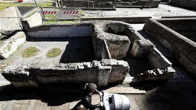 A man pushes a pram as he walks along the Foro Traiano Roman ruins in Rome. AFP