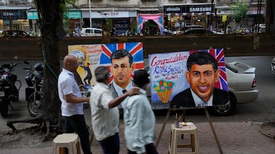 An artist paints a picture of British Prime Minister Rishi Sunak in Mumbai, India. AP