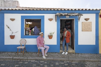 Christian Louboutin chatting in front of the Portuguese handicraft shop Vida Dura in an alley in the village of Melides. AFP