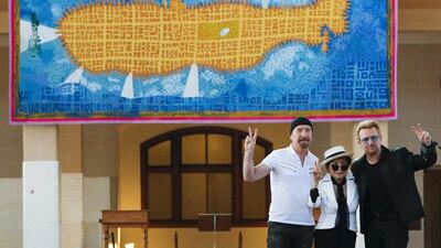 Artist Yoko Ono, centre, widow of John Lennon, poses with Irish singer Bono, right, and guitarist The Edge of U2 during the unveiling of a tapestry honoring Lennon at Ellis Island in New York. Eduardo Munoz / Reuters