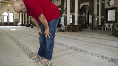 Abdelkhader Moumen, who has significant joint pains, performs prayer. Antonie Robertson / The National