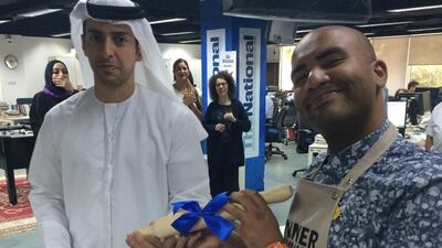 Editor-in-chief Mohammed Al Otaiba presents Hussain Almoosawi with a rolling-pin for winning the fourth annual bake-off. Laura Koot / The National