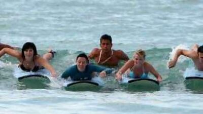 Scott Chambers, second right, managing director of Surf Dubai, teaching students how to surf at Jumeriah beach in Dubai.