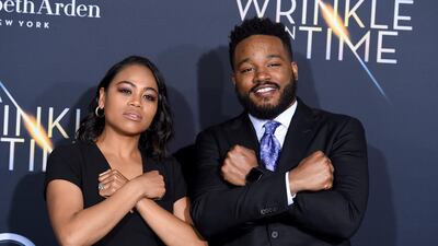 Zinzi Evans, left, and Ryan Coogler gesture the "Wakanda Forever" symbol from the film "Black Panther" as they arrive at the world premiere of "A Wrinkle in Time" at the El Capitan Theatre on Monday, Feb. 26, 2018, in Los Angeles. AP