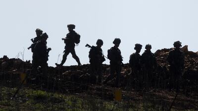 Israeli soldiers walk along the buffer zone between Northern Israel and Southern Lebanon. Despite troops withdrawal from Southern Lebanon, Israeli military remain at five Southern Lebanese posts. Getty Images