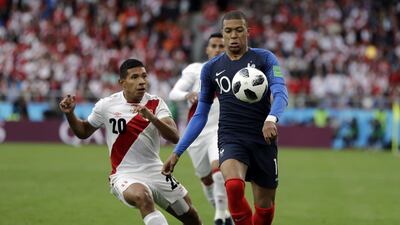 France's Kylian Mbappe, right, is challenged by Peru's Edison Flores. Natacha Pisarenko / AP Photo