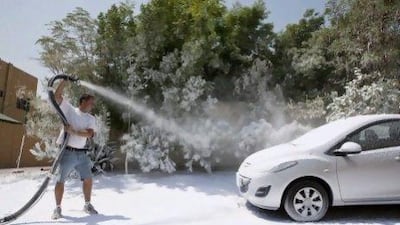 Ben Elliott-Scott, managing director of Desert Snow, sprays a typical street side scene in Jumeirah with artificial snow typically used on movie sets and stages. ANTONIE ROBERTSON / The National