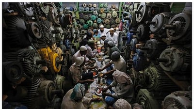 Anwaar Hussain, 35, having iftar with his co-workers and employer inside a shop in the old quarters of Delhi, India, June 14, 2016. Hussain, a mechanic who repairs second hand electric motors and water pumps, says that Ramadan is about self improvement and kindness, and that one should stay away from all evil. Photo by Adnan Abidi