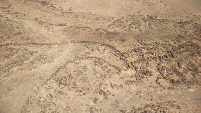 Aerial view of a V-shaped kite on the eroded eastern edge of the Harrat ’Uwayrid. The guide walls of this kite curve and converge towards a cliff edge, at the bottom of which a collapsed enclosure can be seen which may have assisted in trapping the target prey. Photo: Royal Commission for AlUla