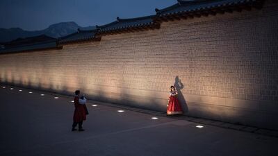 People wearing traditional Korean hanbok dress pose for photos as they visit Gyeongbokgung palace in central Seoul on November 4, 2016. Ed Jones / Agence France-Presse