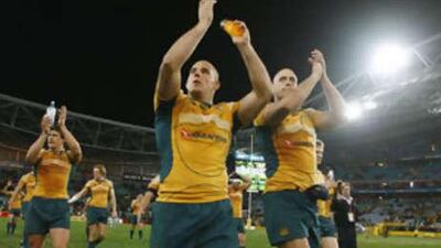 Australia's Stephen Moore, centre, and Nathan Sharpe, right, celebrate their team's victory over New Zealand in the Tri Nations.