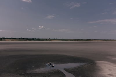 A worker from Spa Rusand tries to collect as much mud as he can at Lake Rusanda, Serbia, which dried up for the first time in recorded history during a prolonged heatwave in July. Getty Images