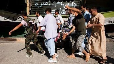 A Syrian rebel (left) helps men carry a civilian wounded by sniper fire to a hospital in the northern city of Aleppo. Fighting in Aleppo, only 50 kilometres from the border, has swelled the number of refugees fleeing to Turkey.