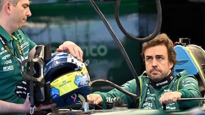 Aston Martin's Spanish driver Fernando Alonso inspects his car with team mechanics in the garage ahead of the Formula One Australian Grand Prix. AFP