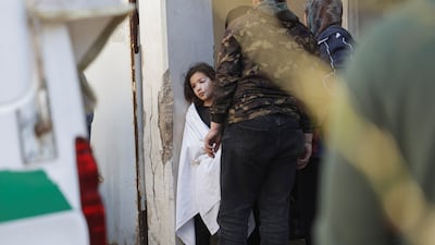 Khadija Hamiyeh looks on as paramedics at Rafik Hariri University Hospital prepare to transport her father's body to be buried, on April 9. He was killed in a strike on the Hay El Sellom district of Beirut. Reuters