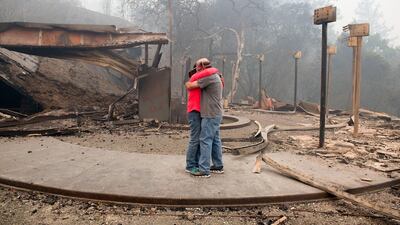 Rhonda Readen hugs her crying partner, Tim Shirley after they arrived to find their home in the Fountaingrove area of Santa Rosa totally destroyed in California. Randy Pench / The Sacramento Bee via AP