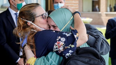Silvia Romano, an Italian aid worker who was kidnapped by gunmen in Kenya 18 months ago, is kissed by her mother, Francesca Fumagalli, at Ciampino military airport in Rome, Italy. Reuters