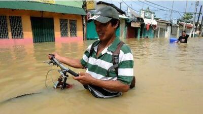A resident pushes through floodwaters yesterday in Calumpit, a town north of the capital, Manila, after Typhoon Nalgae. Jay Directo / AFP