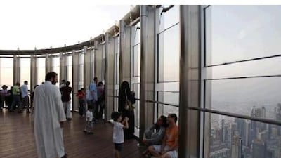 A boy takes a picture of his parents at the observation deck of the world's tallest building, the Burj Khalifa. The landmark is one of the many exciting draws for tourists. Kamran Jebreili / AP Photo