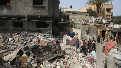 Palestinians look at the destruction after an Israeli strike on a house in Nuseirat refugee camp, central Gaza, on Sunday. AP