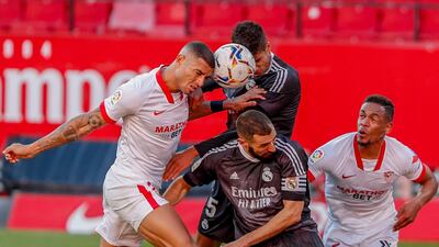 Real Madrid's Karim Benzema, second right, and Raphael Varane centre top, fights for the ball with Sevilla's Fernando and Diego Carlos, left. AP