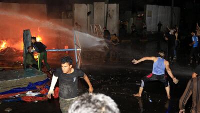 Protesters clash with riot police near the local government headquarters in Karbala on Friday. EPA