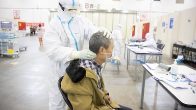 A medical staff in protective suit massages a patient at Wuhan Fang Cang makeshift hospital in Wuhan, Hubei Province, China. EPA